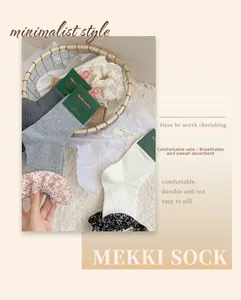 Détail de chaussettes en coton côtelé avec bordure en dentelle florale aux tons neutres