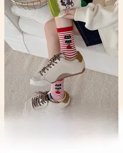 Detail of red and white striped cotton socks with cute apple and cat pattern for women