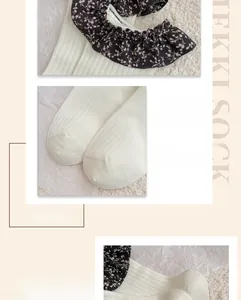 Détail de chaussettes en tricot blanc avec bordure florale et pointe de pied renforcée