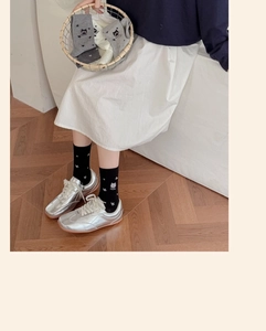Détail de chaussettes en coton avec broderie chat et texte MEOW portées par un mannequin