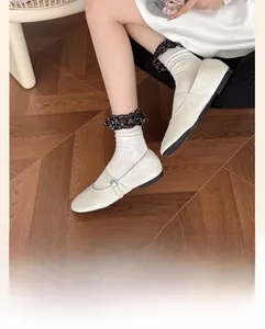 Chaussettes blanches en coton côtelé avec volants floraux noirs portées avec Mary Janes