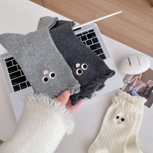 Detail of cute embroidered cartoon eyes on soft cotton lace socks in three colors
