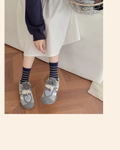 Détail de chaussettes rayées en coton peigné portées avec des baskets rétro stylées