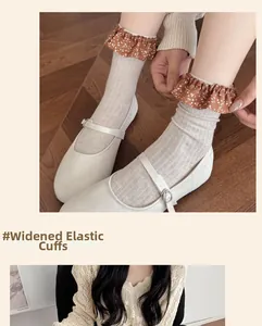 Détail de chaussettes tricotées beige vintage avec dentelle florale et revers élastiques