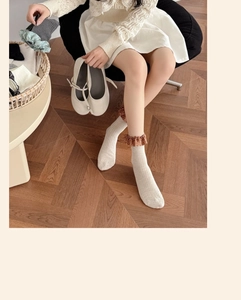 Détail des chaussettes en maille beige avec bordure en dentelle à fleurs marron au revers