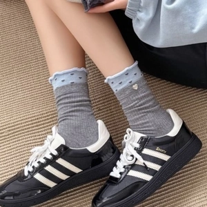 Gray mid-calf socks with blue ruffled heart cuffs and metal heart charm detail