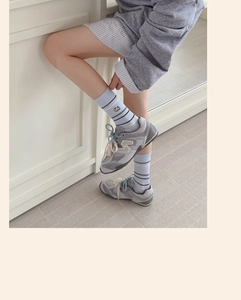 Détail de chaussettes en coton bleu clair à rayures avec broderie chien et texture côtelée