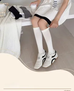 Close-up of white cotton knee-high socks showing material texture and elasticity
