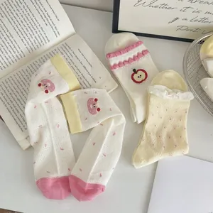 Detail of sweet mesh crew socks featuring apple embroidery and polka dot lace trim