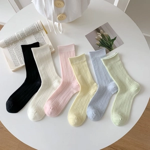 Détail de chaussettes en résille colorées avec rayures verticales et motifs losanges