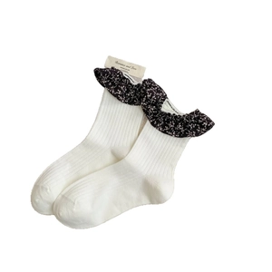 Chaussettes côtelées crème avec bordure à volants floraux noirs et emballage carton