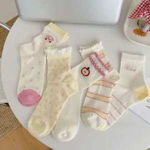 Flat lay of five pairs of cute mesh socks featuring apple and polka dot patterns