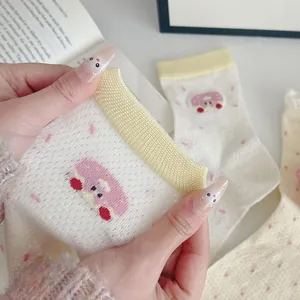 Detailed macro view of mesh knit mid-calf socks with pink mushroom embroidery and dot pattern