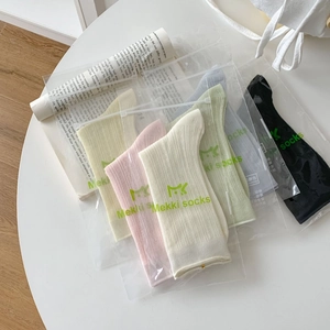 Détail de chaussettes côtelées multicolores en sachets zippés à maille fine