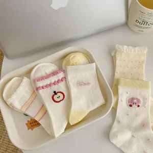 Detail of five pairs of sweet mesh socks with apple embroidery and pink polka dots
