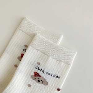 Gros plan de chaussettes blanches en coton avec broderie de chien et motifs à pois