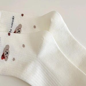 Détail de chaussettes blanches en coton côtelé avec motif de chien et texte thématique