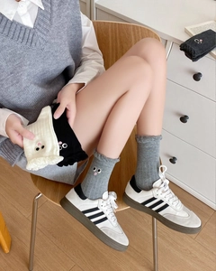 Detailed view of knitted cotton socks with cute eye embroidery and ruffled edges