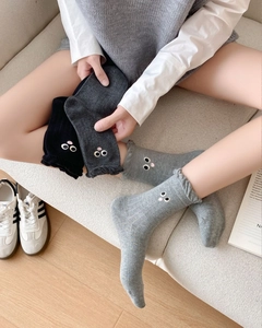 Detailed view of women's cotton socks with lace trim and cute eye embroidery