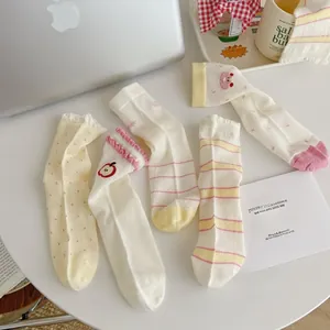 Close-up of five pairs of cream mesh socks with cute fruit and dot patterns