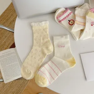 Detail of Japanese style mesh crew socks with fruit patterns on a cozy desk background