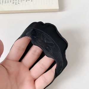 Close-up of black liner socks featuring butterfly-shaped silicone anti-slip heel grips