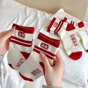 Détail de chaussettes d'examen rouges et blanches avec broderies porte-bonheur