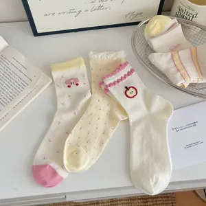 Detailed view of cute embroidered apple and mushroom patterns on soft mesh crew socks