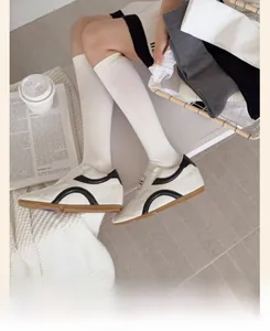Close-up of white calf socks paired with retro low-top sneakers in a cozy home setting