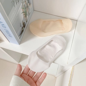 Detail of two pairs of breathable low-cut invisible socks in beige and white