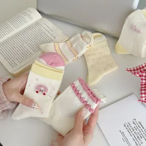 Detailed view of sweet embroidered mesh socks with frilled cuffs and cute patterns