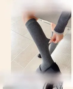 Detail of grey knit sock showing the widened elastic cuff and high fabric stretchability