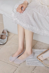 Close-up of light grey ice silk no-show socks worn with silver Mary Jane shoes