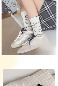 Detail of elastic ribbed cuff and cartoon cat print on white mid-calf cotton socks