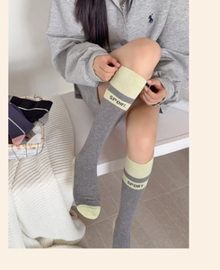Détail de chaussettes montantes grises sport avec pointe vert clair et imprimé SPORT