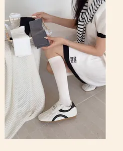 Three-pack cotton ribbed knee-high socks in black grey and white on model