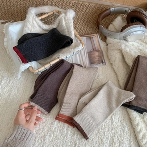 Cozy autumn winter knit socks in various earth tone colors on soft white faux fur rug