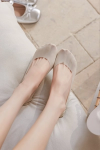 Close-up of nude ultra-thin invisible socks worn with silver ballet flats for a natural look