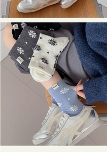 Dettaglio del motivo a fiocchi di neve ed etichetta Yumy su calze invernali in cotone