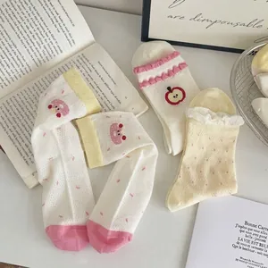 Chic women mesh crew socks with apple embroidery and polka dots in a home setting