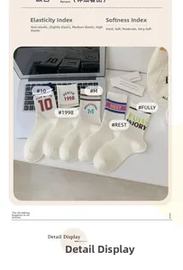 Detail view of five pairs of cream white athletic crew socks with varsity embroidery