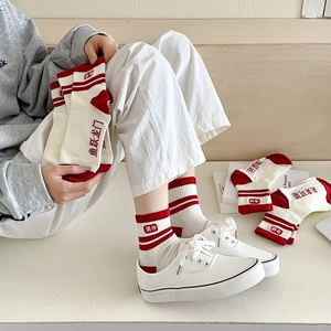Détail de chaussettes en coton rouge et blanc avec caractères chinois et rayures et baskets