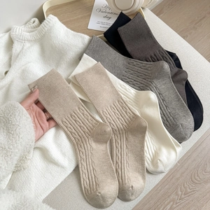 Five pairs of cable-knit crew socks in neutral autumn colors with soft texture