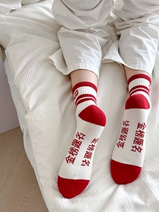 Vue macro de chaussettes en coton rouge et blanc avec texte et rayures Jinbang Timing