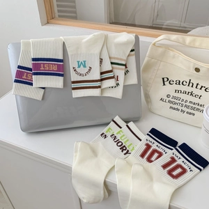 Retro collegiate style cotton crew socks with athletic stripes and typography