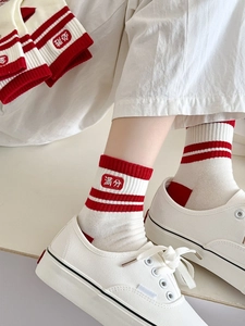 Détail de chaussettes en coton blanc avec rayures rouges et caractères chinois porte-bonheur