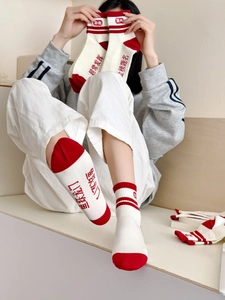 Détail de chaussettes d'examen rouges et blanches avec texte inspirant et rayures