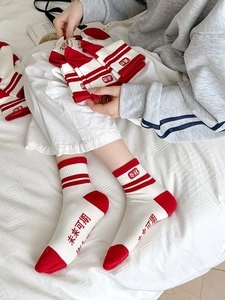 Détail de chaussettes en coton rouge et blanc avec typographie chinoise inspirante