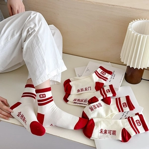 Vue détaillée de chaussettes en coton rouge et blanc avec slogans de réussite brodés