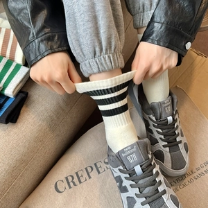 Detail showing high-elasticity ribbed cotton crew socks with athletic stripes